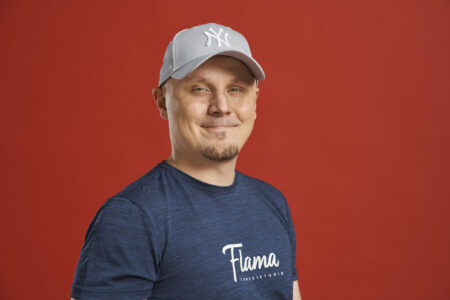 Henkilö seisoo ja poseeraa kameralle. Päällään sininen paita, jossa lukee "Tanssistudio Flama" ja päässään lippalakki. Kuvassa Tuomas Sirviö.