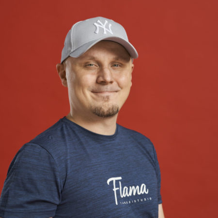Henkilö seisoo ja poseeraa kameralle. Päällään sininen paita, jossa lukee "Tanssistudio Flama" ja päässään lippalakki. Kuvassa Tuomas Sirviö.